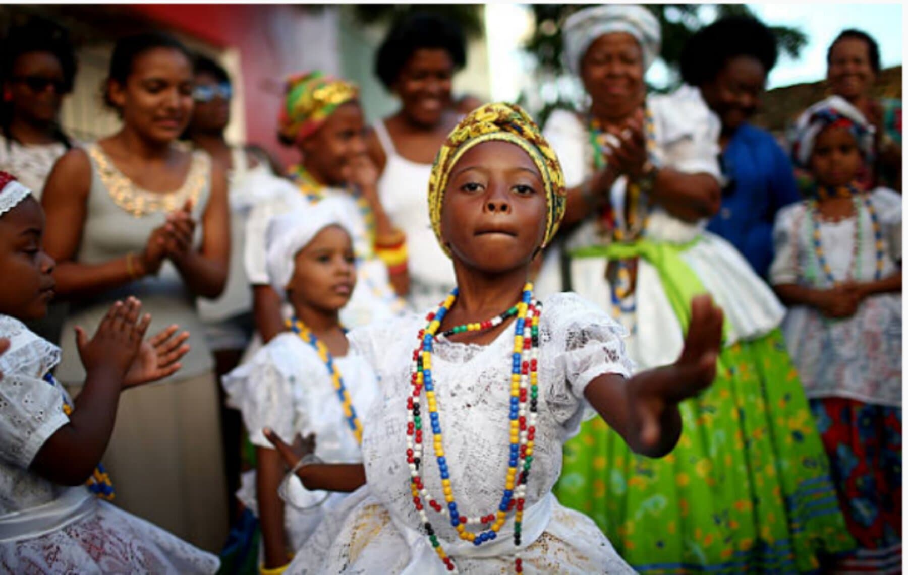 Elder woman in traditional dress adorned with beads and flowers, Cachoeira — generational wisdom and cultural legacy