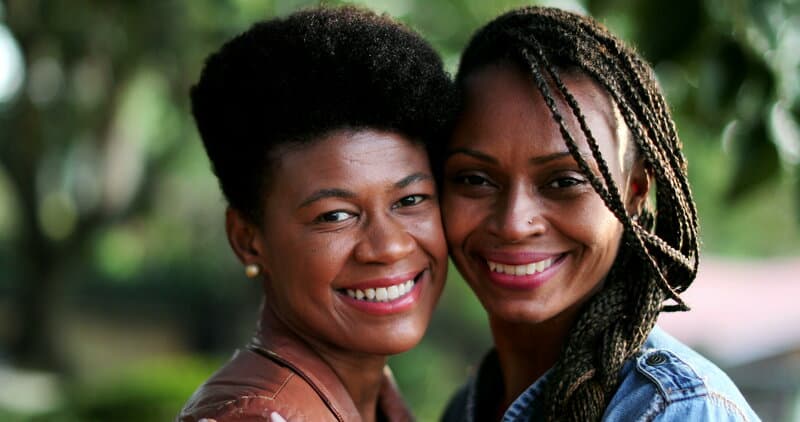Two Black women smiling together outdoors